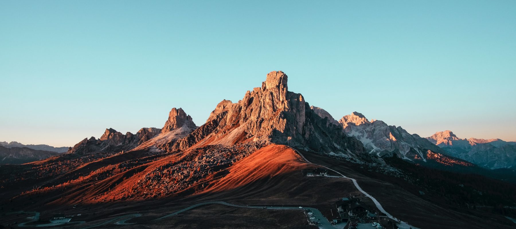 Sunlit mountain range with clear blue sky