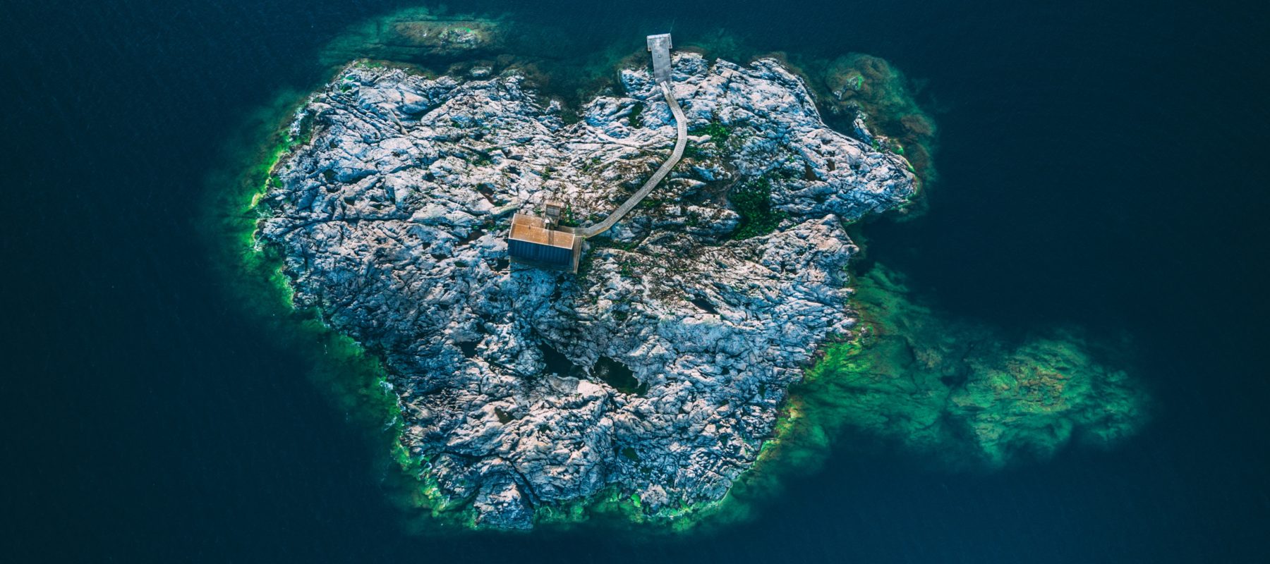 Aerial view of rocky island with small building